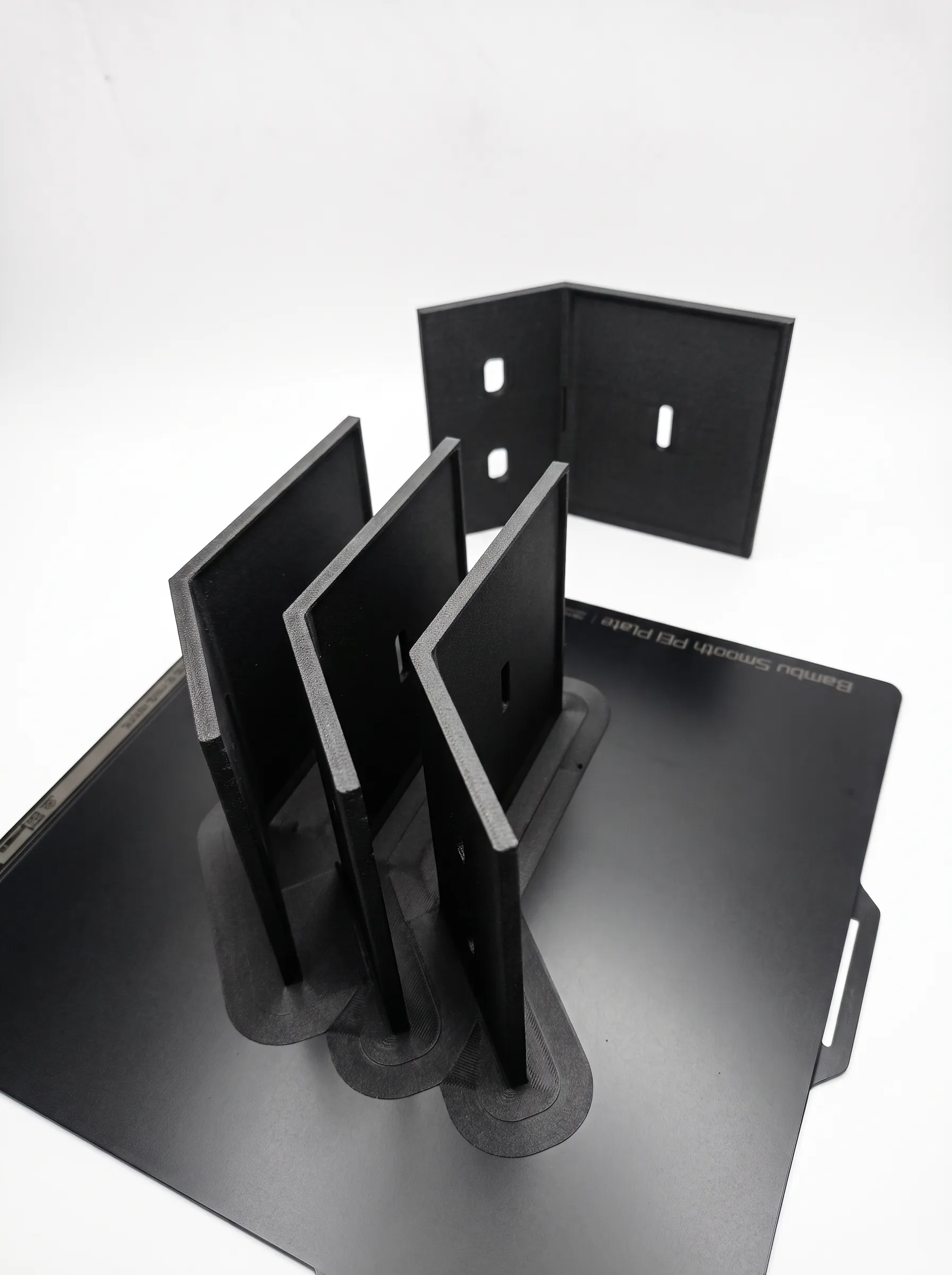 Set of four black PET-CF L-brackets for an outdoor solar panel mount, fresh off the print bed