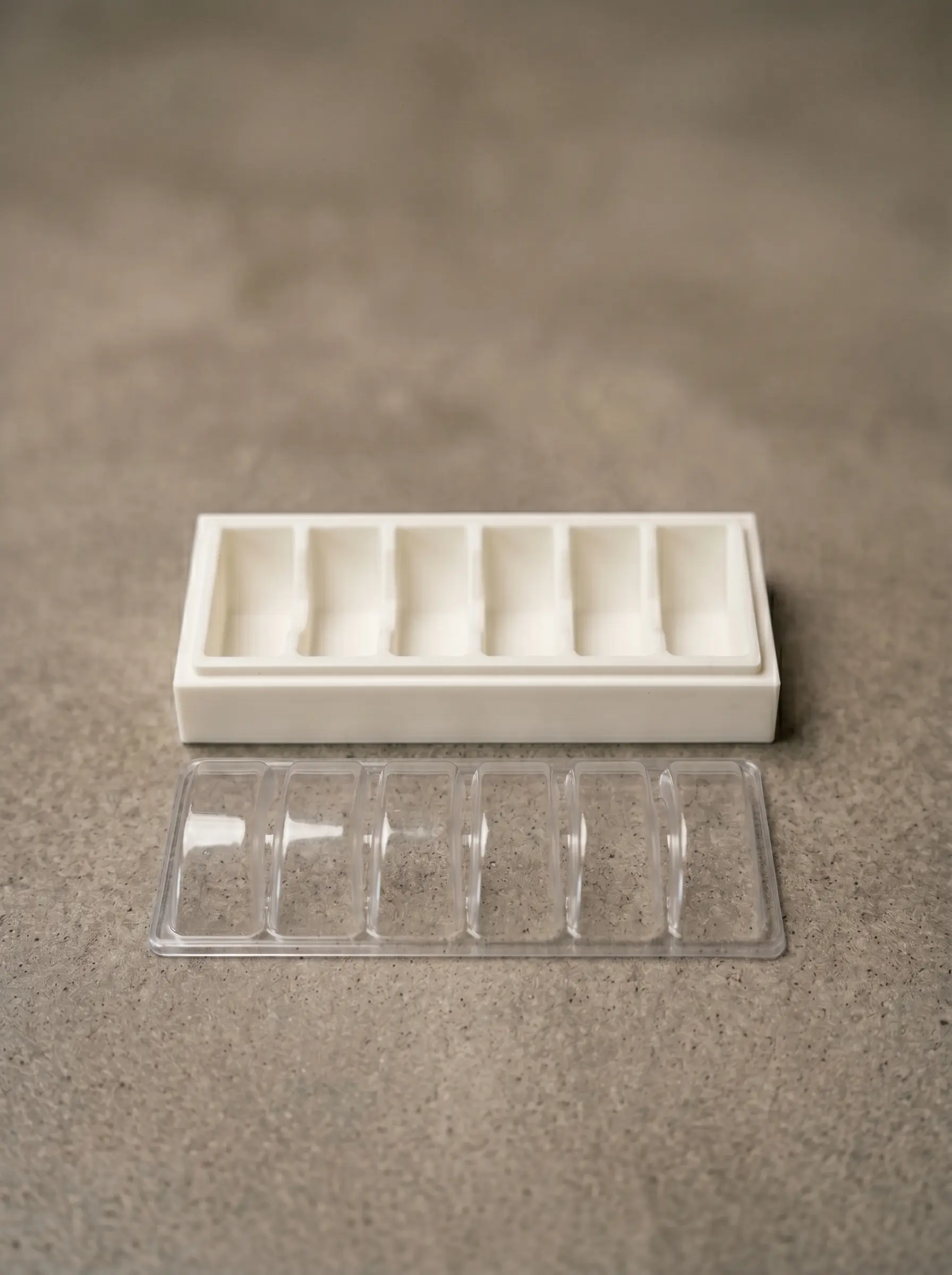 Vacuum-forming positive plug printed in PLA, paired with the resulting clear thermoformed 6-cavity blister tray